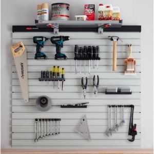A wall mounted tool rack with a variety of tools.