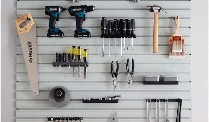 A wall mounted tool rack with a variety of tools.