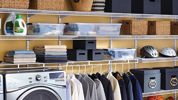 A laundry room with clothes, towels, and baskets that has been organized with Custom Closet Design.