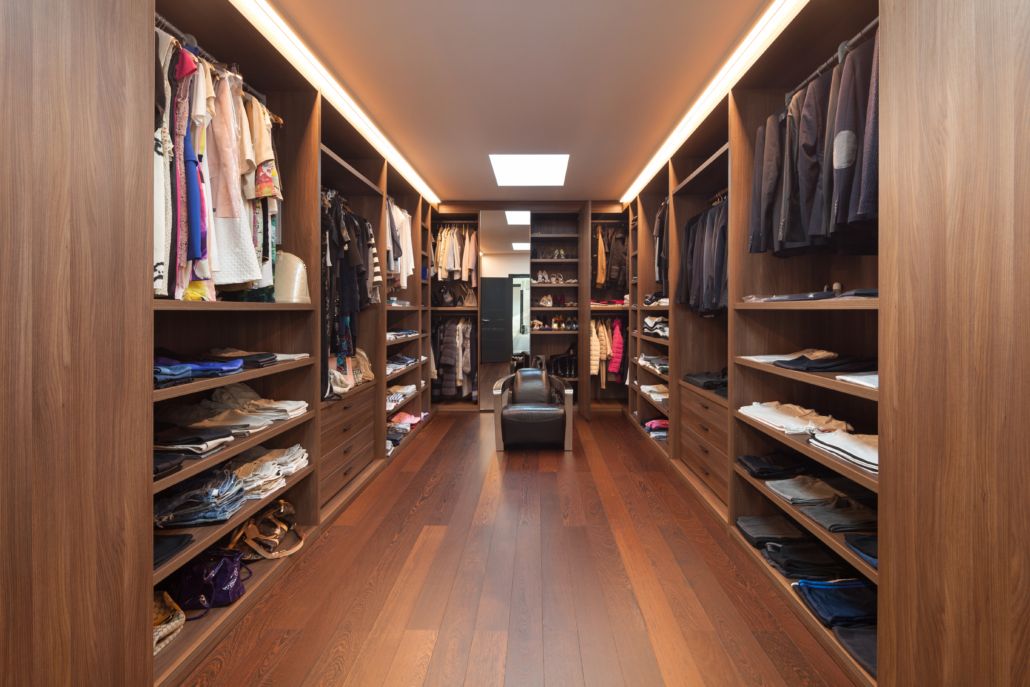 A Custom Closet Design with a wooden floor.
