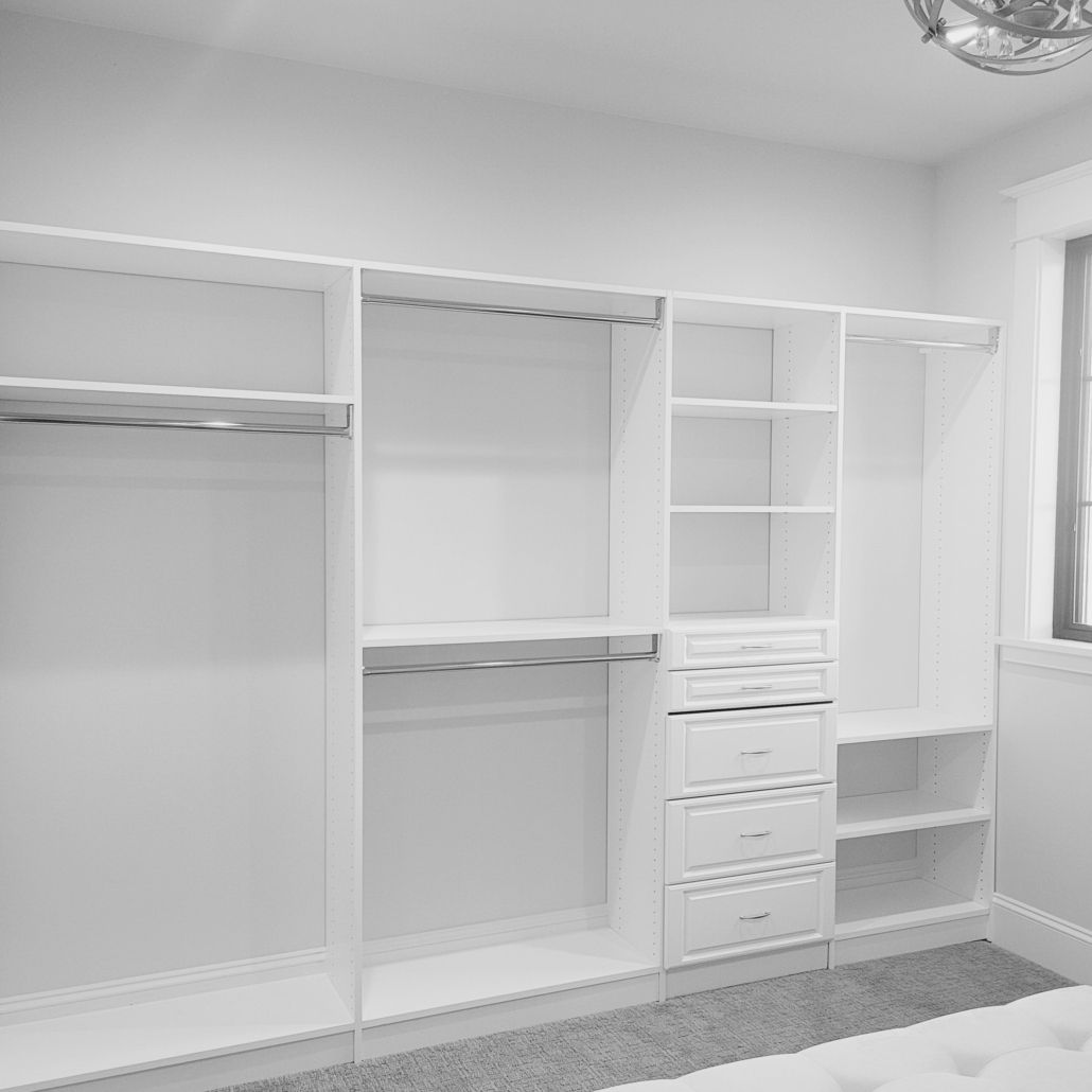 A white closet with a white dresser and drawers featuring organization systems.